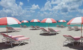 a group of lawn chairs sitting on top of a beach