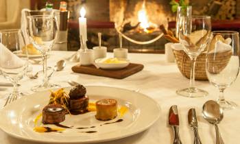 a plate of food and glasses of wine on a table