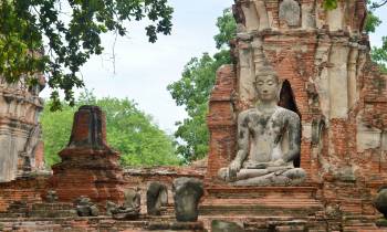 a large stone statue in front of a brick building