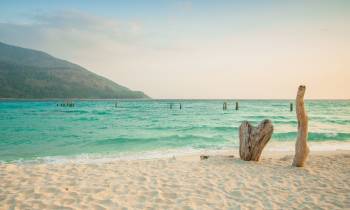 a sandy beach next to a body of water