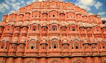 a large brick building with Hawa Mahal in the background