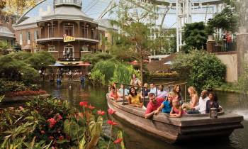 a group of people on a boat in the water with Gaylord Opryland Resort & Convention Center in the background