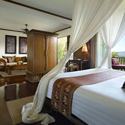 a bedroom with a bed and a chair in a room