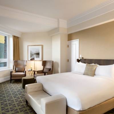 a bedroom with a bed and desk in a hotel room