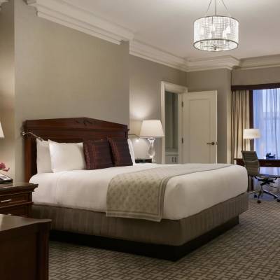 a bedroom with a bed and desk in a hotel room