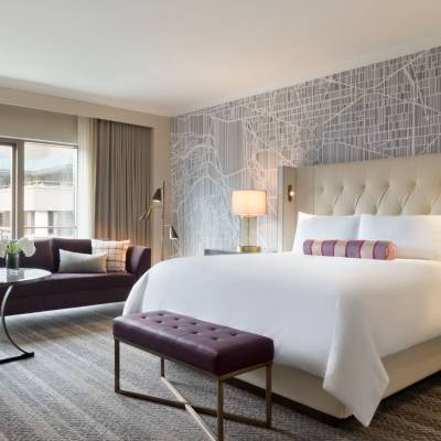 a bedroom with a bed and a chair in a room