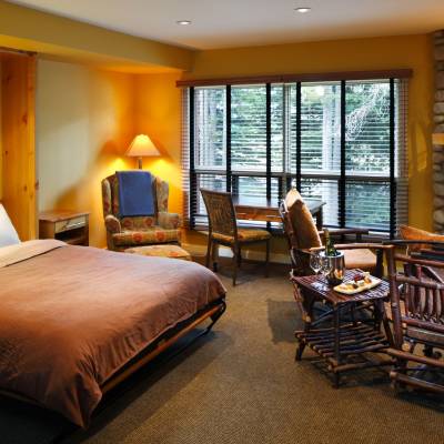 a bedroom with a bed and a chair in a room