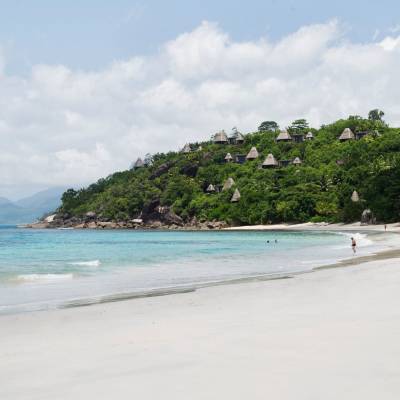 a sandy beach next to a body of water