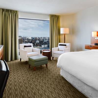 a bedroom with a bed and desk in a hotel room