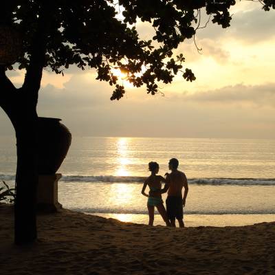 a couple of people on a beach near a body of water