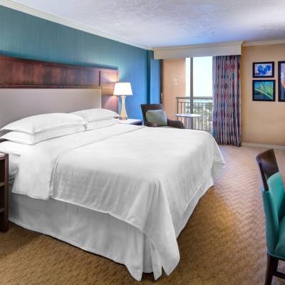 a bedroom with a bed and desk in a hotel room