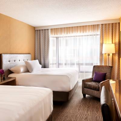 a bedroom with a bed and desk in a hotel room