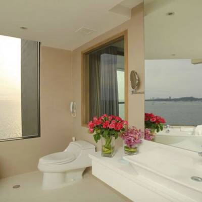 a row of pink tub and sink and a mirror