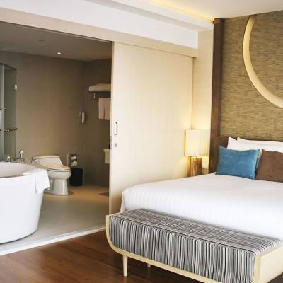 a bedroom with a bed and desk in a hotel room