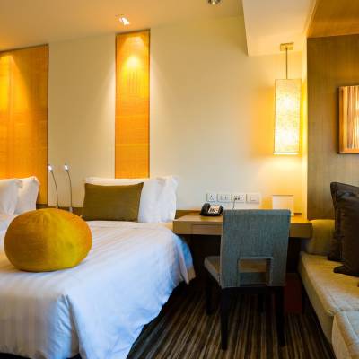 a hotel room with a bed and looking at the camera
