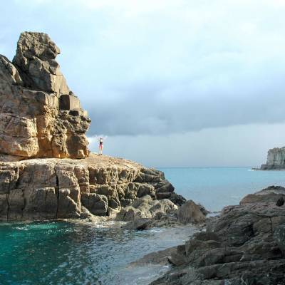 a rocky island in the middle of a body of water
