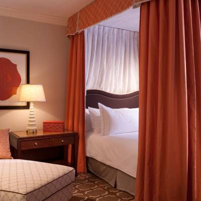 a bedroom with a bed and desk in a hotel room