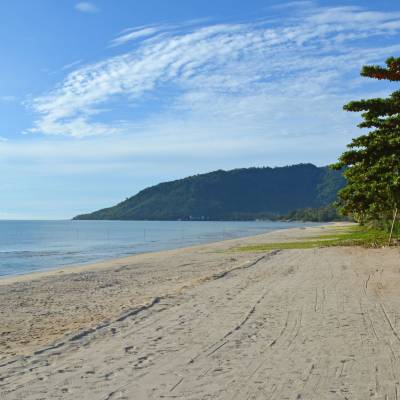 a sandy beach next to a body of water