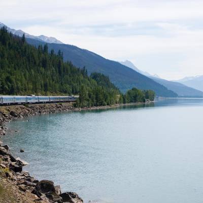 a train traveling down tracks next to a body of water