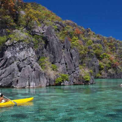 a yellow boat sitting on top of a rock