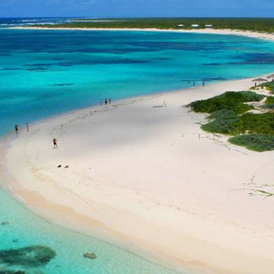 a sandy beach next to a body of water