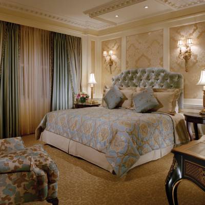 a bedroom with a bed and a chair in a room