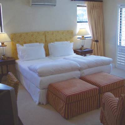 a bedroom with a bed and a chair in a room