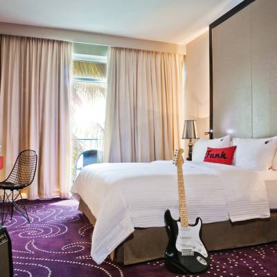 a bedroom with a bed and desk in a hotel room