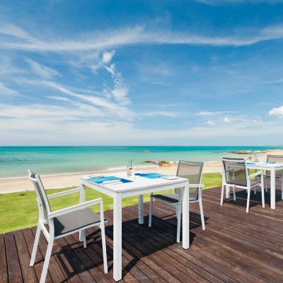 a group of lawn chairs sitting on top of a sandy beach