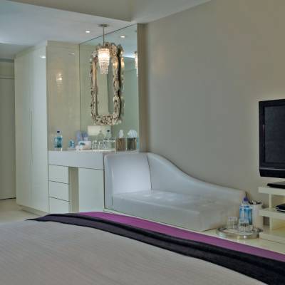 a bedroom with a bed and a mirror in a room