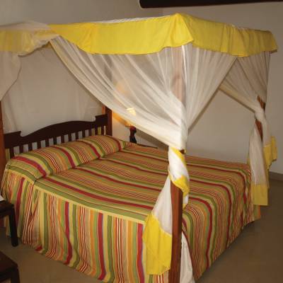 a bedroom with a bed and a chair in a room