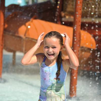 a young girl riding a wave on top of a building