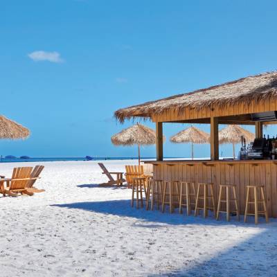 a group of lawn chairs sitting on top of a sandy beach