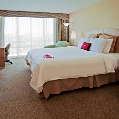 a bedroom with a bed and desk in a hotel room