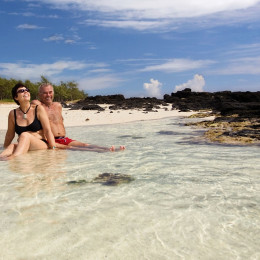 Enchanting Travels Mauritius tours couple is sitting together on a white sand beach