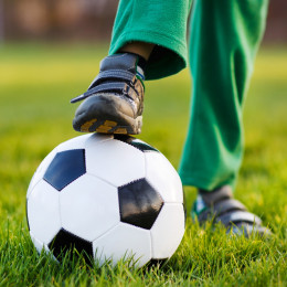 Boy stepping on a football