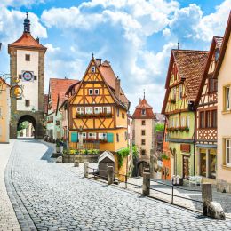Beautiful postcard view of the famous historic town of Rothenburg ob der Tauber on a sunny day with blue sky and clouds in summer, Franconia, Bavaria, Germany