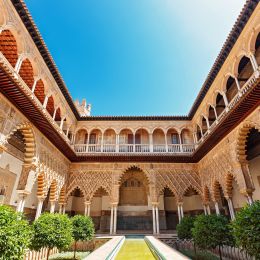 Things to do in Spain - Palace of Alcazar, Famous Andalusian Architecture. Old Arab Palace in Seville, Spain. Ornamented Arch and Column. Famous travel destination.