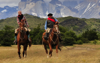 Frau reitet mit Gaucho durch das Gebirge von Patagonien, Argentinien