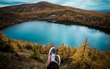 Blick hinunter auf idyllischen See inmitten bergiger Wälder