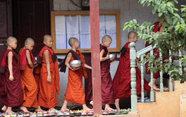 Eine Gruppe von jungen buddhistischen Mönchen geht die Treppe eines Hauses in Myanmar hinauf