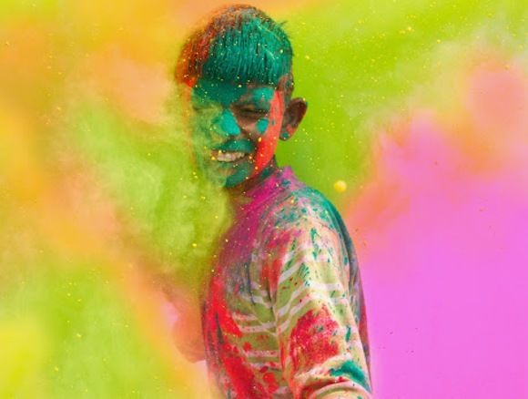 Holi, Fest der Lichter - Junge wird mit Farben beworfen