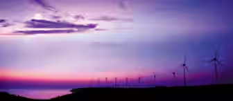 A serene scene of a coastal landscape at dusk, featuring a row of wind turbines silhouetted against a vibrant sky with shades of purple, pink, and blue. The moon is partially visible amidst wispy clouds, and the sea reflects the twilight hues. Stars dot the sky.