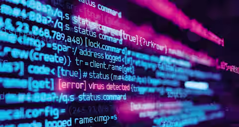 A close-up of computer code displayed on a screen, with lines of code in vibrant blue, pink, and purple colors. One line of text is highlighted in red, stating "[error] virus detected," indicating a security issue within the code.