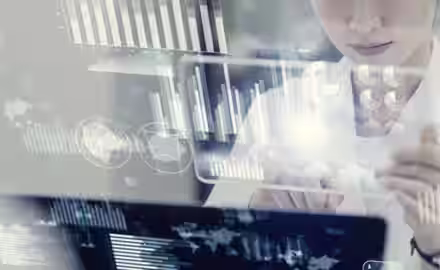 A person interacts with a transparent digital touchscreen displaying graphs, charts, and data visualizations, suggesting analysis or work with advanced technology and big data.
