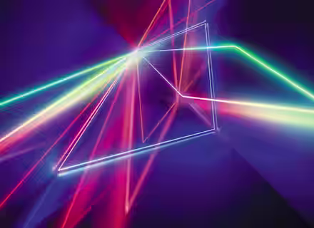 Abstract image featuring vibrant, intersecting neon light trails in pink, blue, yellow, and green on a dark purple background. The lights form geometric shapes and create a sense of depth and motion.