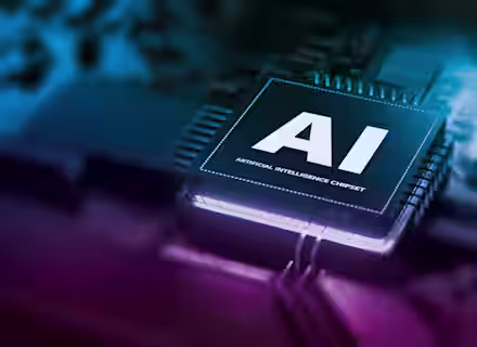 Close-up of a computer chip labeled "AI Artificial Intelligence Chipset" on a circuit board, with glowing blue and purple lights highlighting the technology.