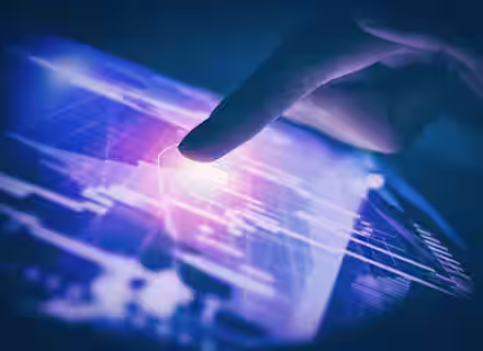 A close-up of a hand touching a digital tablet screen, emitting a bright glow. The screen displays various abstract graphics, charts, and data points, indicating technology and data interaction. The overall color scheme is predominantly blue and pink.