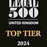 A black rectangular badge with the text "The Legal 500 United Kingdom" in large white letters, followed by the text "Top Tier 2024" in gold letters at the bottom.