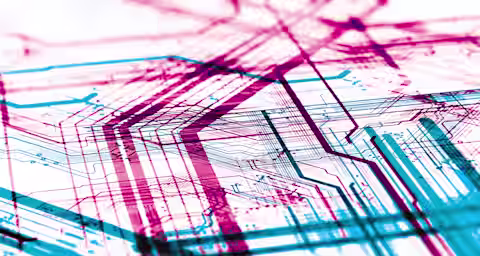 Abstract image of a complex circuit board design with overlapping red and blue lines, illustrating the intricate pathways and connections of an electronic system. The image emphasizes the detailed and layered structure of the circuitry.